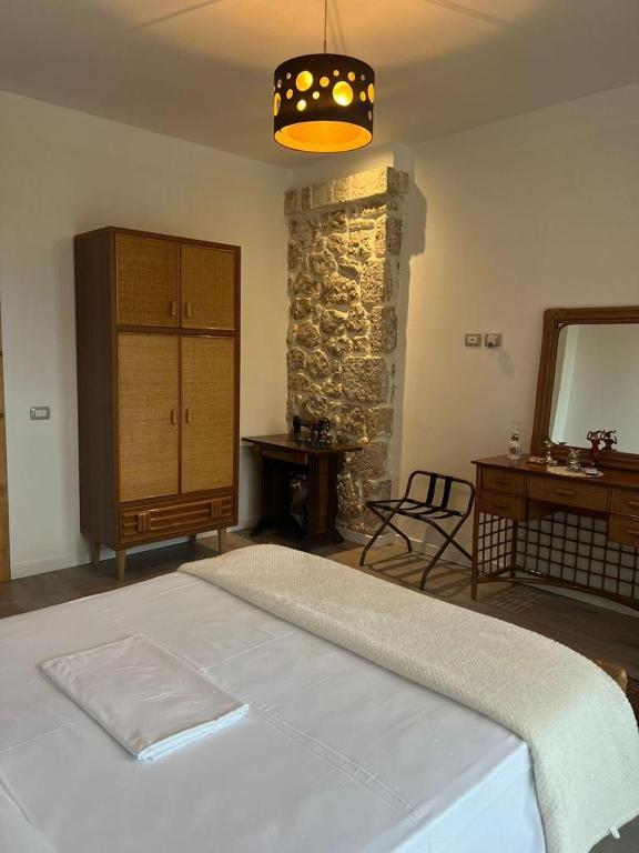 a bedroom with a bed and a dresser and a mirror at Rahoni Park & Suites in Dhërmi