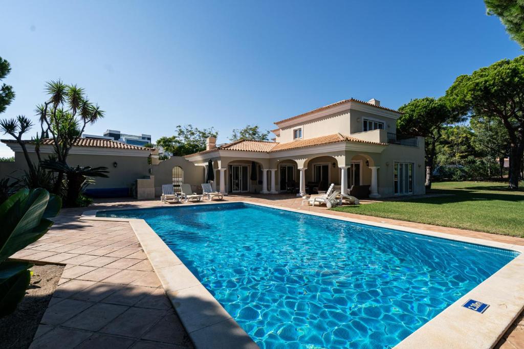 a swimming pool in front of a house at Casa Atlantico in Quinta do Lago