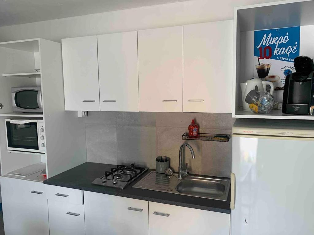 a kitchen with white cabinets and a sink at LE DEPOT appartement du port à Champvert in Champvert