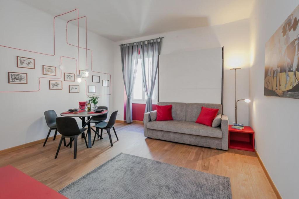 a living room with a couch and a table and chairs at "Casa Picasso" Elegant Studio in the Heart of Genova in Genova
