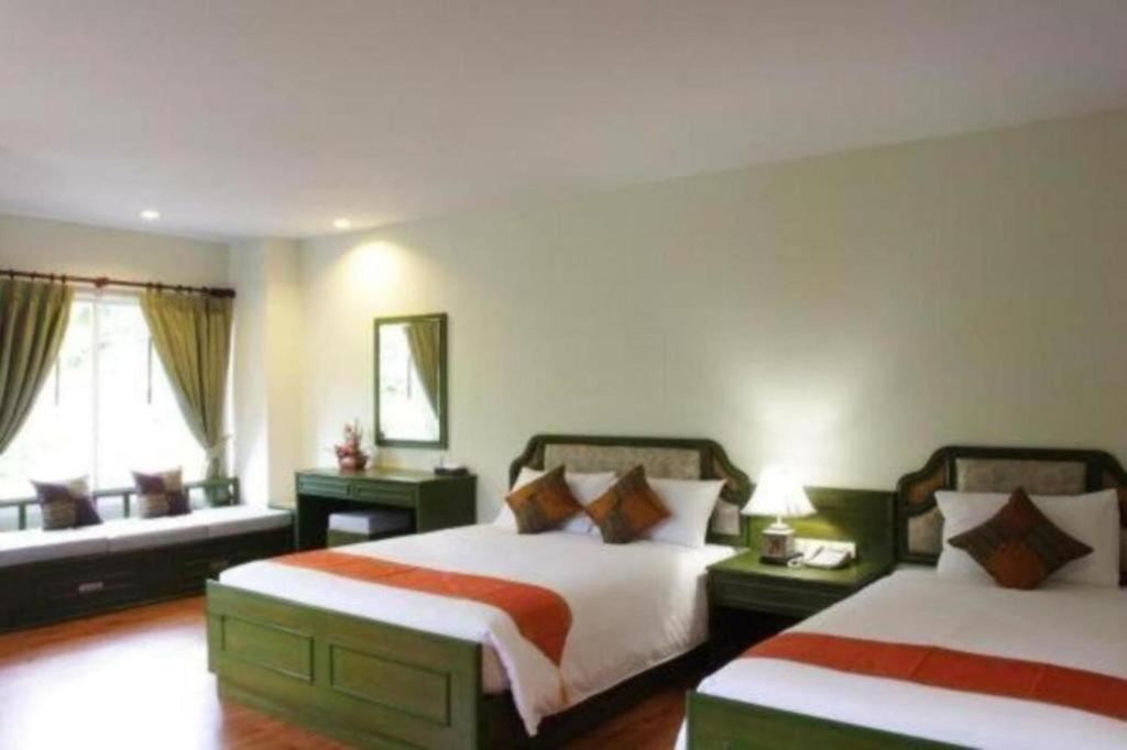 小查汶海灘的住宿－查汶海塔拉酒店，酒店客房设有两张床和窗户。