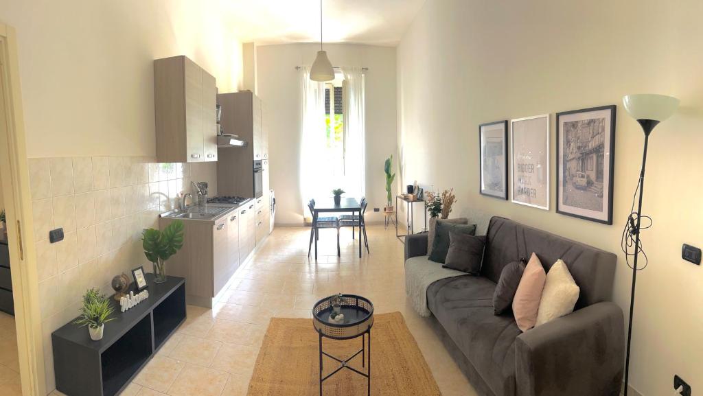 a living room with a couch and a kitchen at Ampio e Confortavole Appartamento a Voghera in Voghera