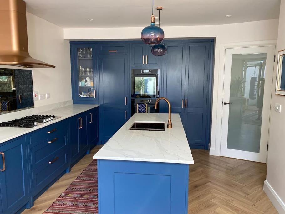 a blue kitchen with a white counter top and blue cabinets at Terenure House in Terenure