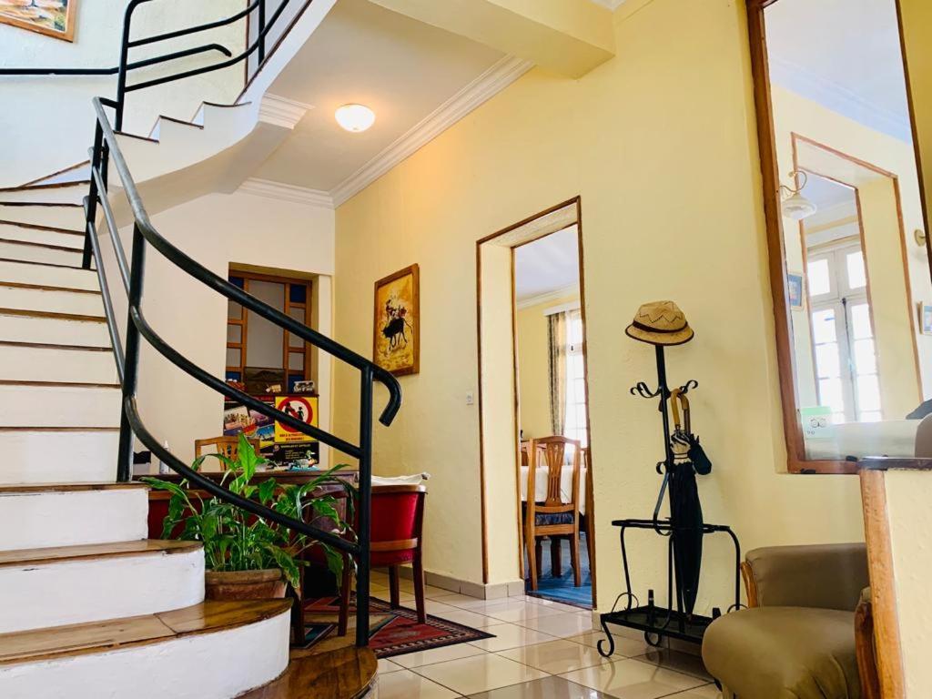 a living room with a spiral staircase with a hat at Résidence Mareva in Antananarivo