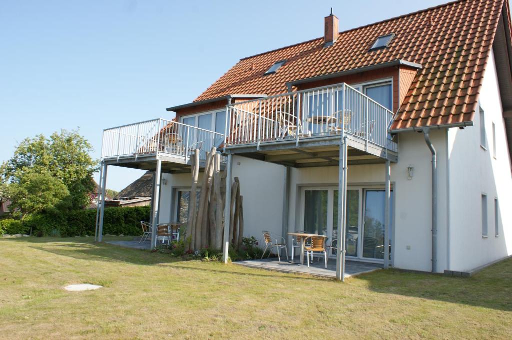 a house with two balconies and a table and chairs at Dock2Apartment Rügen Whg 3 großer Balkon, ruhige Lage in Lohme