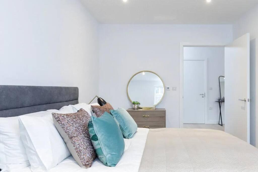 a bedroom with a bed with pillows and a mirror at Cosy 2 bedroom Apartment-Zone 1 in London