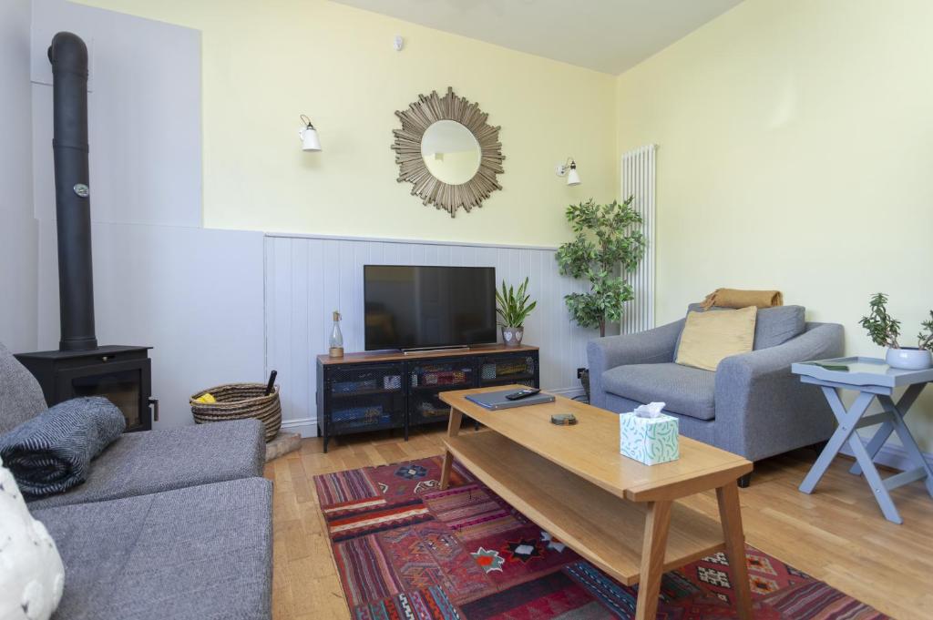 a living room with a couch and a tv at The Old Schoolhouse in Whitstable