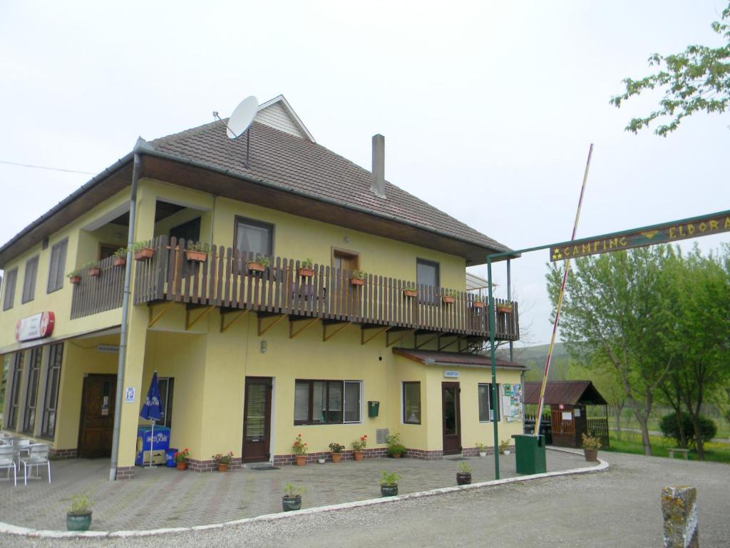 a yellow building with a balcony on top of it at Camping Eldorado in Gilău