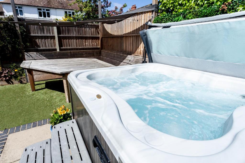 a jacuzzi tub in a backyard with a table at The Old Schoolhouse in Whitstable