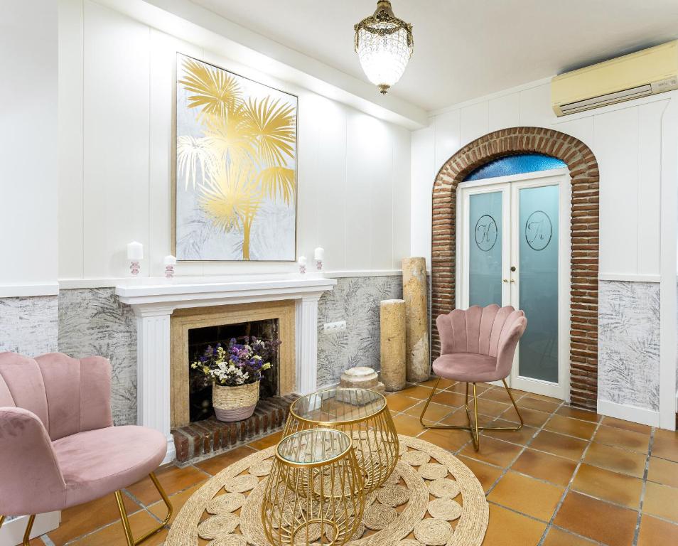 uma sala de estar com cadeiras cor-de-rosa e uma lareira em Puerta De Aduares em Marbella