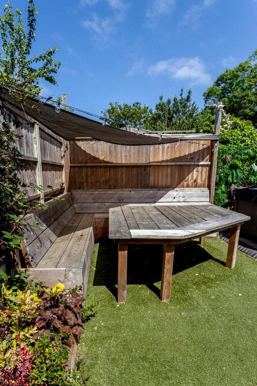 a wooden bench sitting in the grass in a garden at The Old Schoolhouse in Whitstable