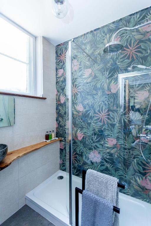 a bathroom with a shower with a glass door at The Old Schoolhouse in Whitstable