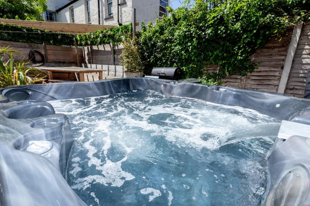 a hot tub with water in it in a backyard at The Old Schoolhouse in Whitstable