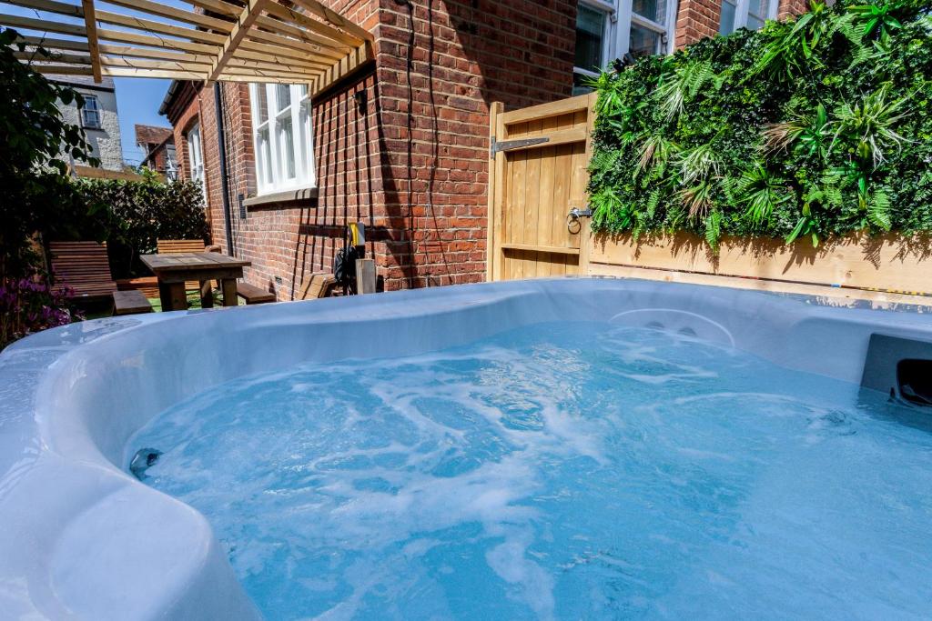 a jacuzzi tub in a yard next to a building at The Old Schoolhouse in Whitstable