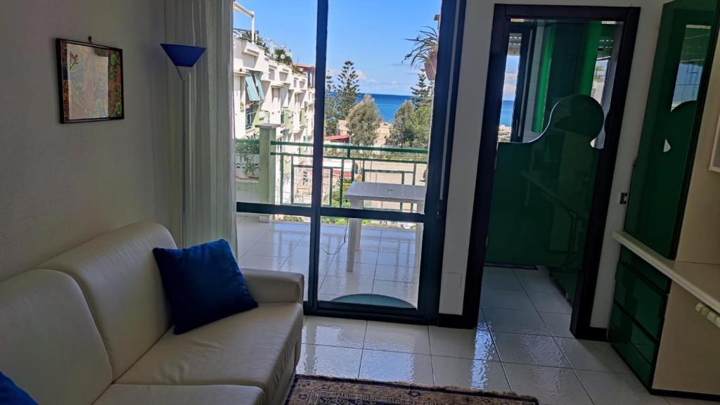 een woonkamer met een bank en uitzicht op de oceaan bij Il Gabbiano casa al mare in Bisceglie