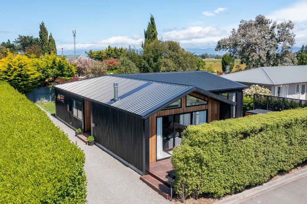 a black house with solar panels on the roof at Black Barn Modern: Luxe Martinborough Escape in Martinborough 
