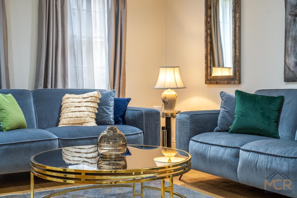 - un salon avec deux canapés bleus et une table dans l'établissement The Shepherd Residence, à Londres