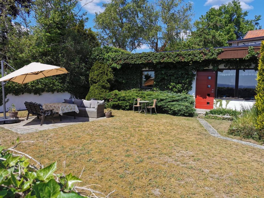 a backyard with a couch and an umbrella at Guest cottege in Ystad