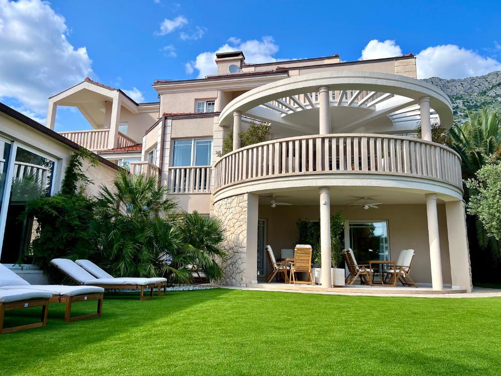 una casa con un gran patio con césped verde en Villa Romana I Omis, en Omiš
