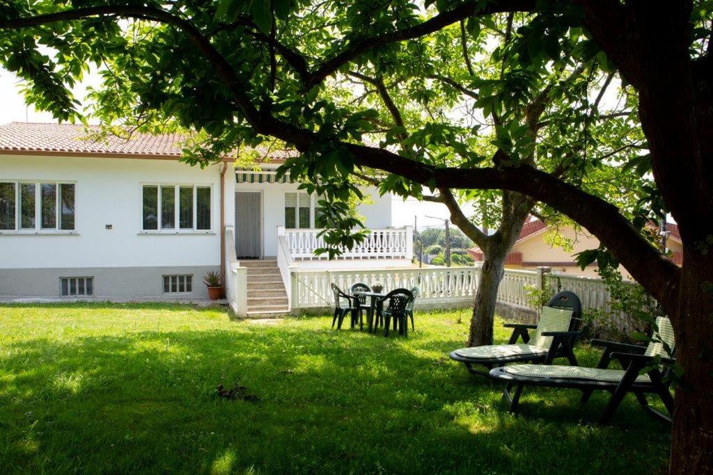un patio con sillas y un árbol frente a una casa en Playa de Perbes - Casa con precioso jardín, en Boebre