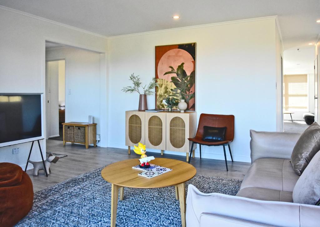 sala de estar con sofá y mesa en Premium Comfortable Lake View 2BR en Taupo