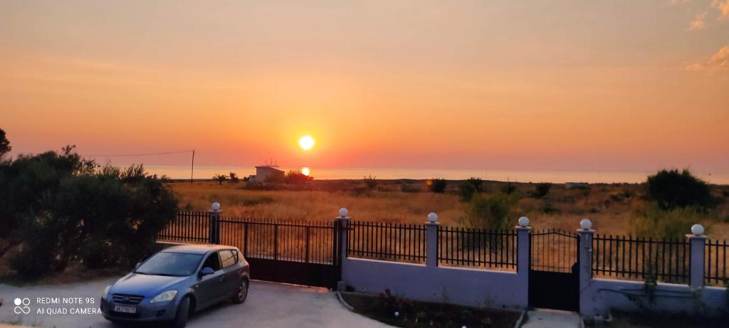 a car parked in a parking lot with the sunset in the background at AGNANTIO HOME in Monemvasia