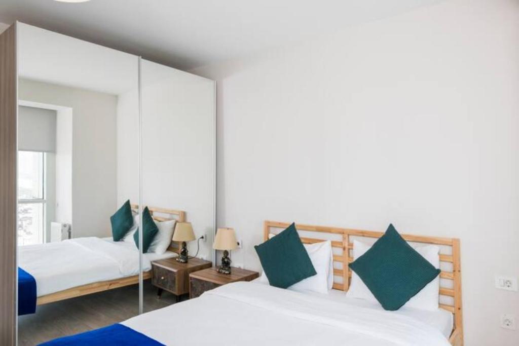 1 dormitorio con 2 camas y espejo en Residence 5 étoiles 26 eme étage 2 plus 1 avec piscine, en Estambul