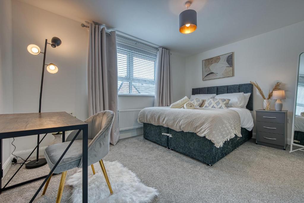 a bedroom with a bed and a desk and a table at Spacious 4 BR House w/Parking in Birmingham