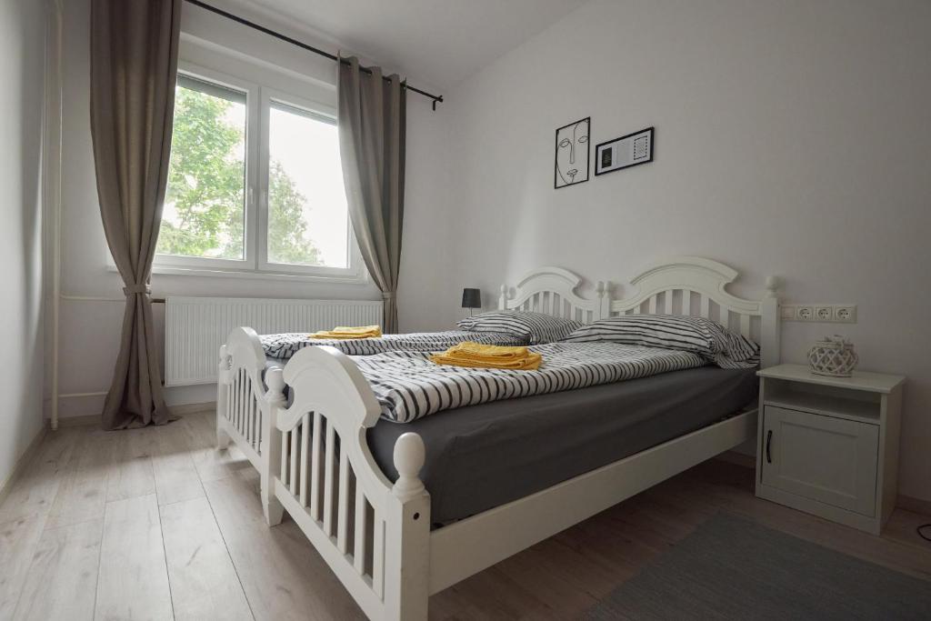 a white bed in a bedroom with a window at Piccoleto Bianco in Badacsonytomaj