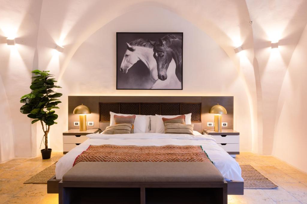 - une chambre avec un grand lit avec 2 chevaux sur le mur dans l'établissement Kassa Boutique Hotel, à Bethléem