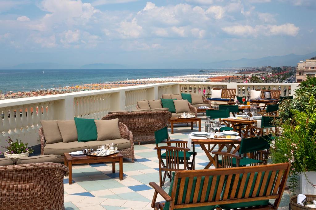a balcony with chairs and tables and the beach at Palace Hotel in Viareggio