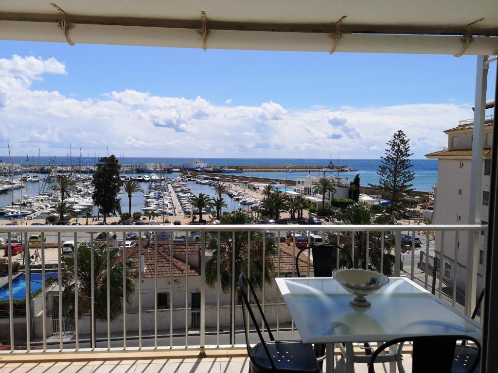 einen Balkon mit einem Tisch und Hafenblick in der Unterkunft Apartamento encantador con vistas al Club Naútico in Altea