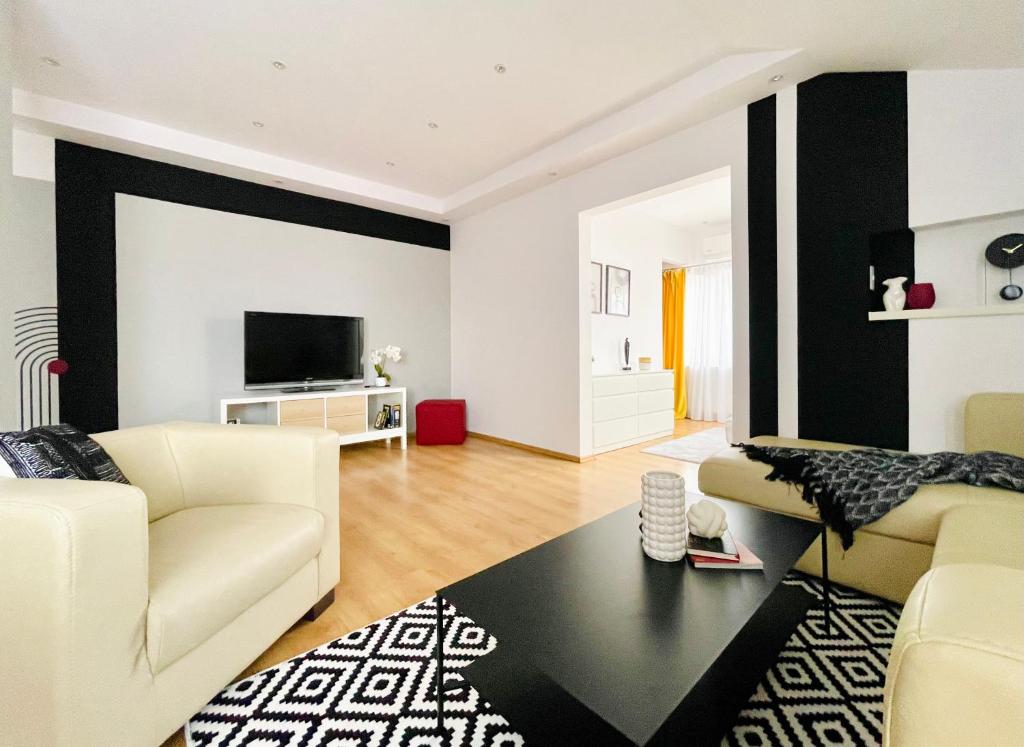a living room with black and white walls and white furniture at R&B apartment in Timişoara
