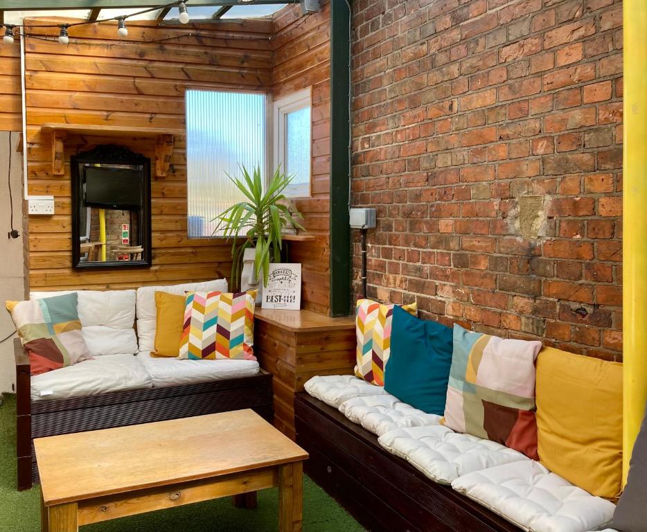 a room with a couch and a brick wall at Central Backpackers in Oxford