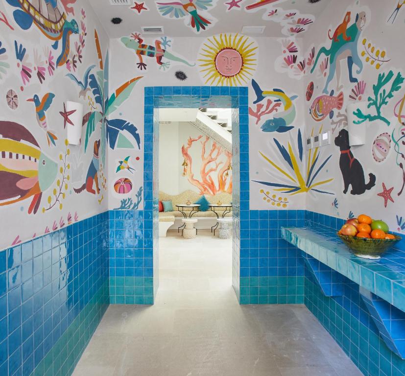 塔里法的住宿－El Escondite Tarifa，浴室铺有蓝色瓷砖,墙上有动物
