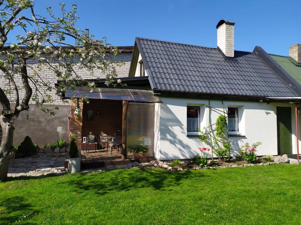 a white house with a patio and a yard at Ele kodumajutus in Pärnu