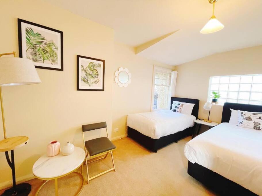 1 dormitorio con 2 camas, mesa y escritorio en Incredible Waterview - 4 Bedroom Hobart Waterside Cottage, en Sandy Bay