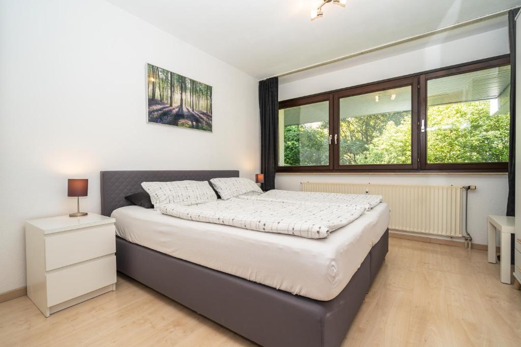 Schlafzimmer mit einem großen Bett und Fenstern in der Unterkunft Appartement Langhammer in Tübingen