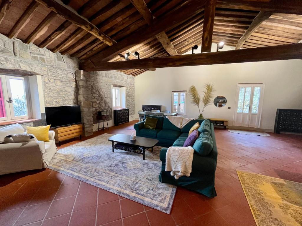 ein Wohnzimmer mit einem Sofa und einem TV in der Unterkunft Servigliana in Popiglio