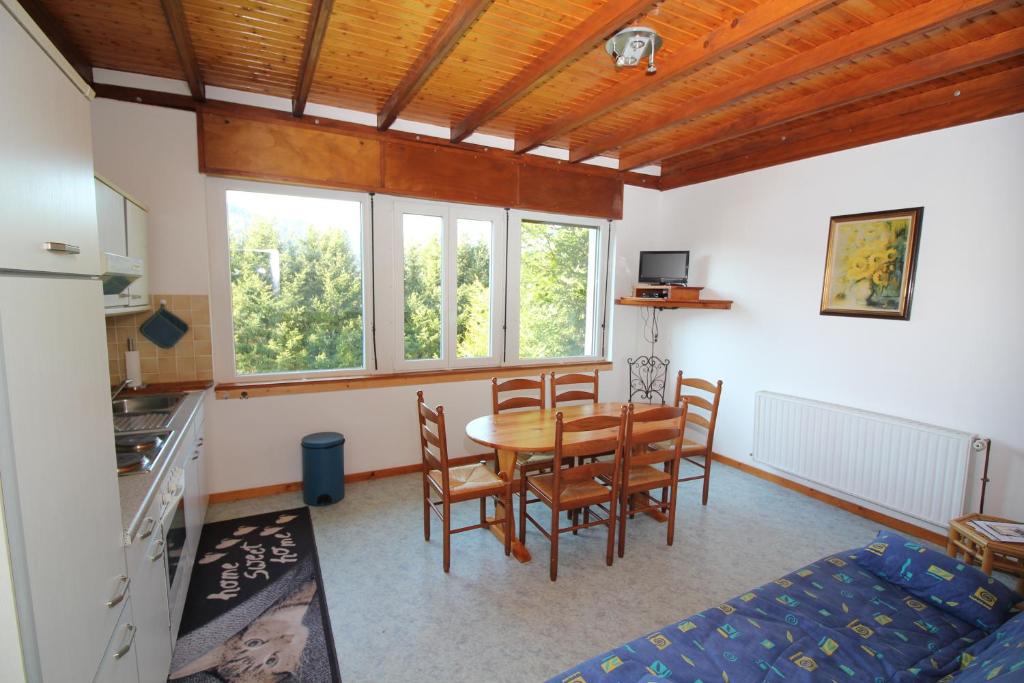eine Küche und ein Esszimmer mit einem Tisch und Stühlen in der Unterkunft Gîte Les Jonquilles in Le Bonhomme