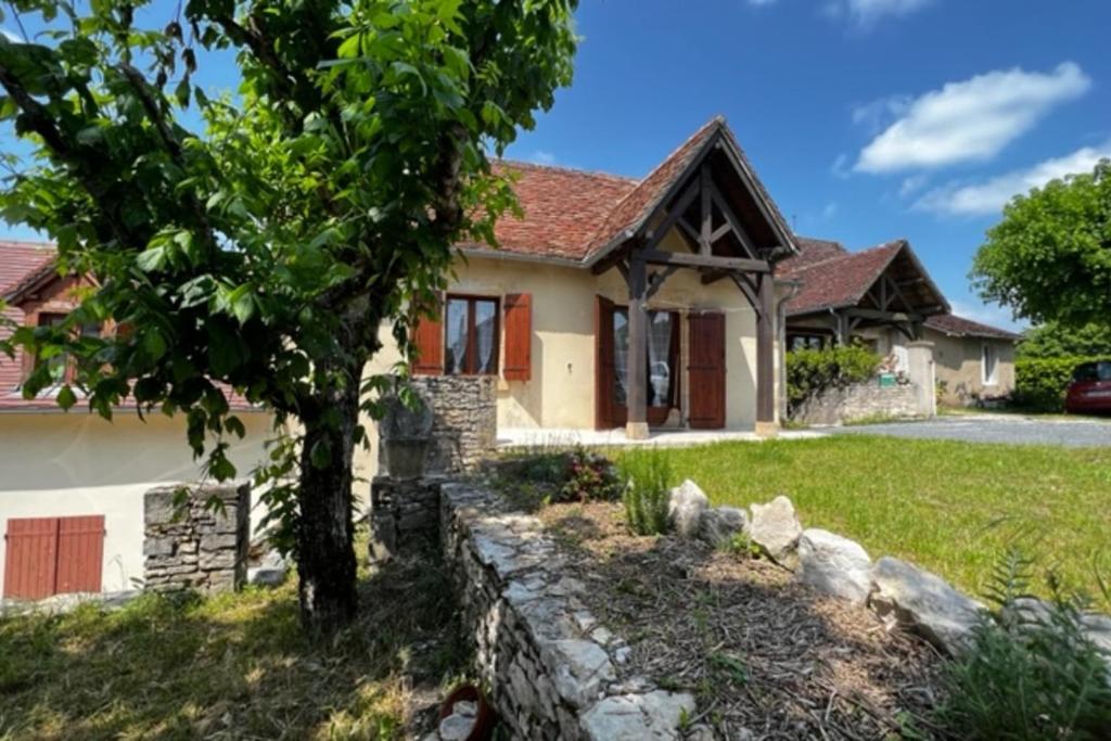 Gite du belvédère à Rocamadour في روكامادور: منزل أمامه شجرة