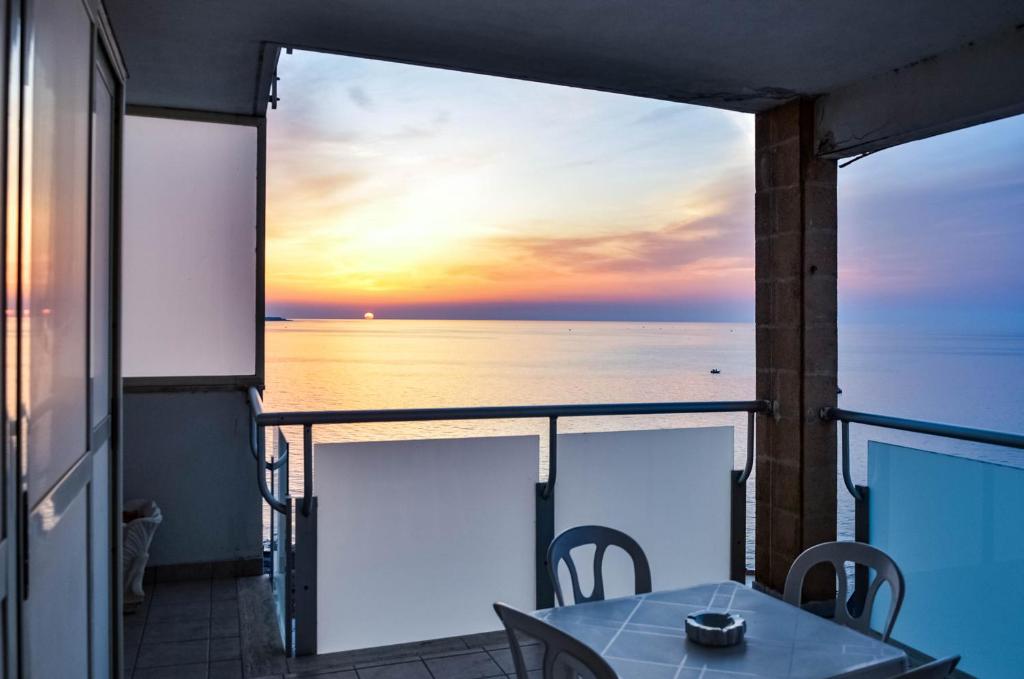 a balcony with a table and a view of the ocean at La casa al faro in Bari