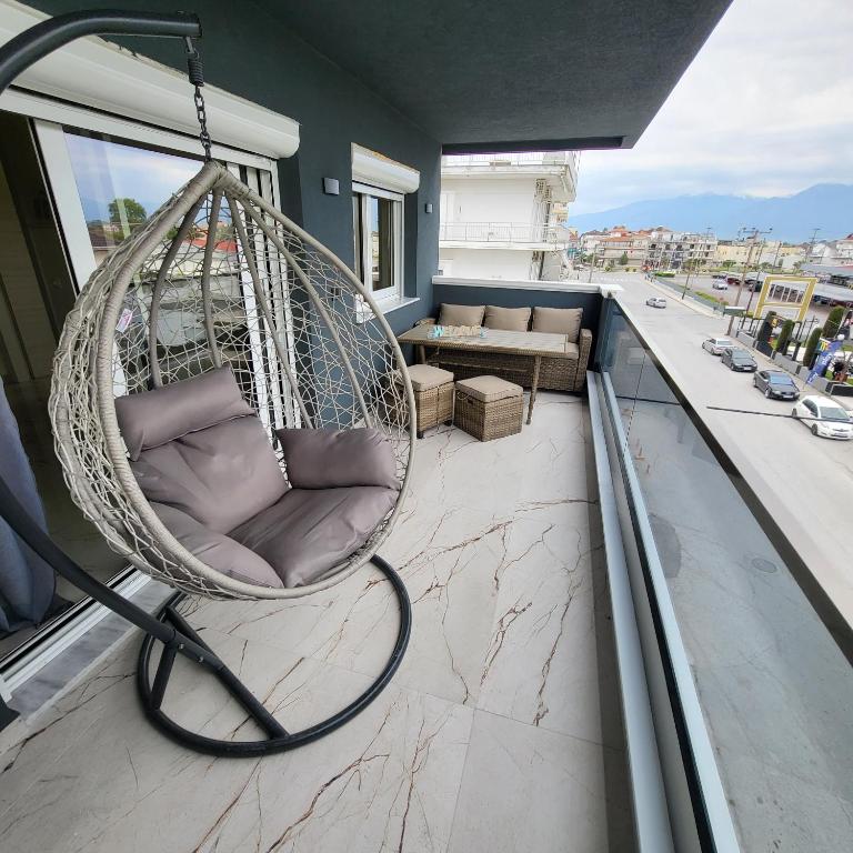 a hanging hammock on a balcony with a couch at Luksuzni Apartman Harmonija Paralija in Paralia Katerinis