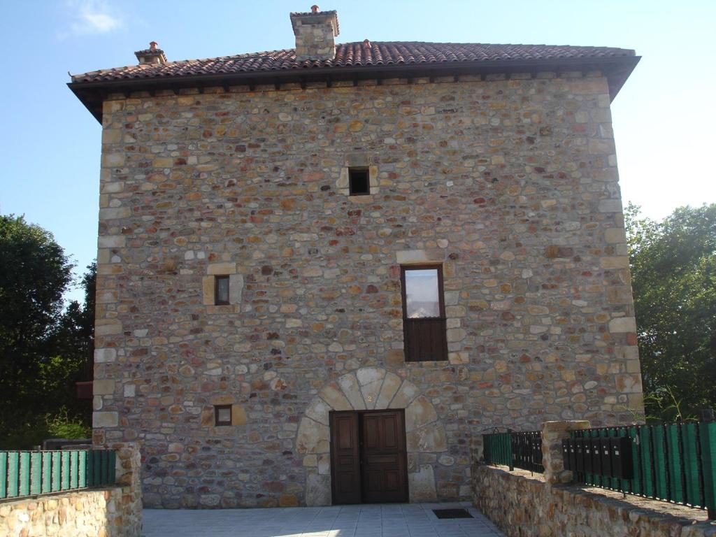 un gran edificio de ladrillo con una puerta. en CASA TORRE DE GURIEZO, en El Puente