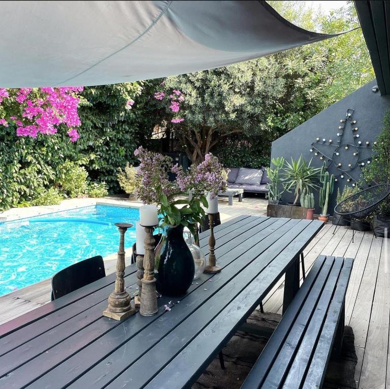 a wooden table with a vase of flowers on it at Luxury Villa Heleni in Herzliya