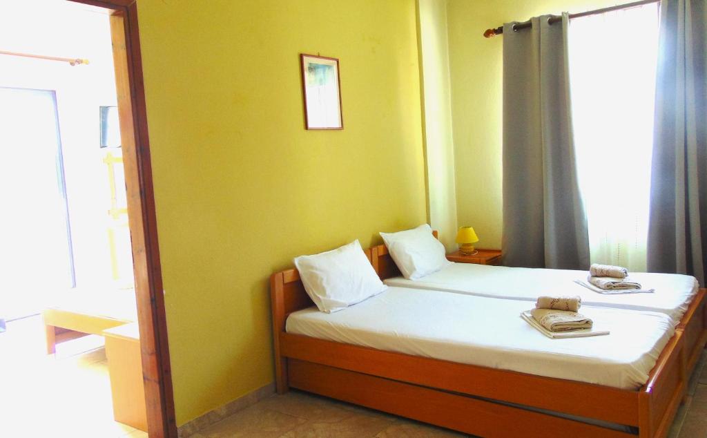 a bedroom with a bed in a room with a window at Central Apartments in Paralia Dionysiou