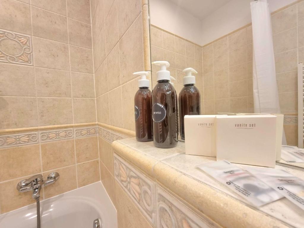 a bathroom with two bottles on a counter next to a sink at Hotel Claris in Prague