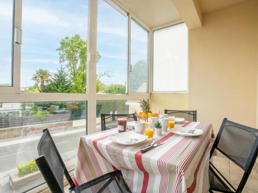 a dining room table with a tablecloth on it with windows at Apartment Avenue de Biarritz by Interhome in Anglet