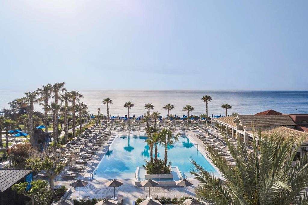 an overhead view of a pool with chairs and the ocean at Esperides Beach Resort in Faliraki