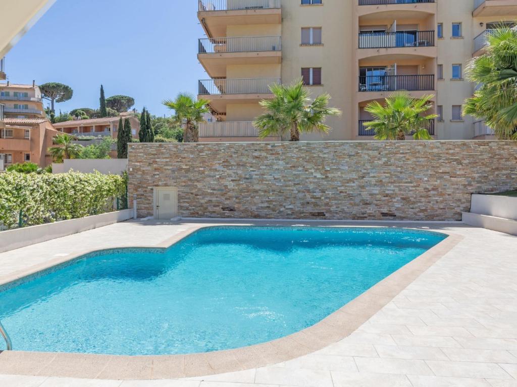 a swimming pool in front of a building at Apartment La Palmeraie II-1 by Interhome in Sainte-Maxime